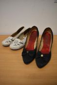 A pair of 1950s black satin shoes with stiletto heel and bow detailing to front and a pair of
