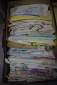 A suitcase of mixed vintage and antique table linen, including embroidered items, lace and