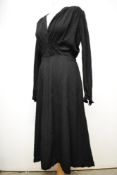 An early 1940s black textured crepe dress, having smocking to shoulders and waist, low V neckline,