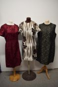 Three vintage 1960s dresses, including bold rose patterned dress and black beaded dress.
