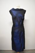 A 1950s gown of metallic blue fabric, having high slash neckline and low back with bow and sash