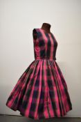 A 1950s cotton day dress, having check pattern in pink, green, and purple tones, replacement zip
