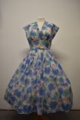 A late 1940s semi sheer day dress, having floral pattern, side metal zip and original belt.