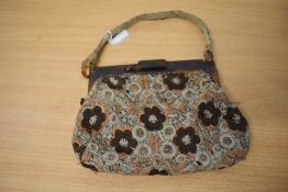 An Art Deco bag, having early plastic frame and clasp and embroidered floral pattern in brown, beige