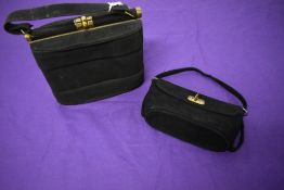 A black suede 1950s handbag having brass frame fastening and a similar example.