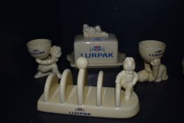 A selection of collectable Lurpak ceramics, including egg cups, toast rack and butter dish.