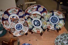 Five 20th century oriental plates in varying Imari hues, having scalloped edges, some having