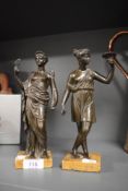 A Pair of Victorian bronze figurines depicting semi nude women in Roman dress, both on marble
