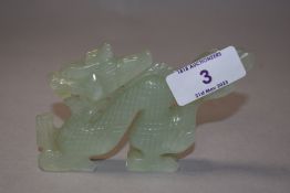 A Chinese carved green stone dragon.