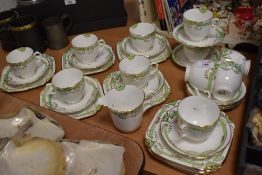 A collection of Longton china Art Deco cups and saucers, side plates and a jug, having green banding