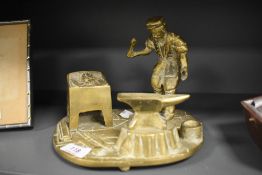 A vintage brass study of a Blacksmith at work, illegible impressed Registration No. To underside.