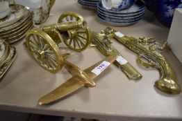 Four vintage novelty ornamental brasses, comprising; cannon, plane and two pistols.
