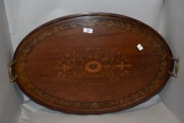 A large 19th century mahogany butlers tray of oval design, having inlaid paterae and metal