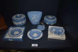 An assortment of blue and white Wedgwood Jasperware, including large trinket boxes, desk top lighter