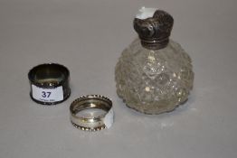 A 19th century cut glass perfume bottle having hall marked silver lid (damage to lid) and two silver