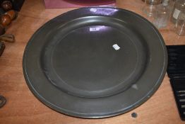A substantial antique round pewter charger of simple form, indistinctly impressed to reverse with