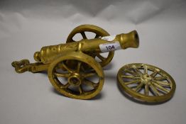 A vintage brass canon and a cartwheel.