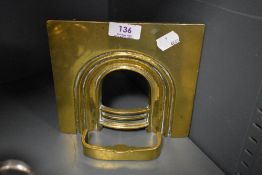 A miniature brass fire place with fender.