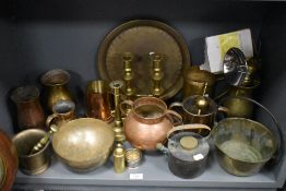 A shelf full of vintage brass and copper wares, pestle and mortar, bowls, candlesticks and more to