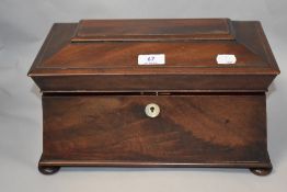 A Victorian mahogany tea caddy, having two internal removable compartments, MOP escutcheon and bun