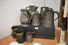 A mixed lot of antique pewter tankards and a jug, some interesting designs and some with many