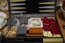 A cased set of games, including cards and dominoes.