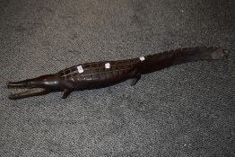 An Ethnic wood carved study of a caiman crocodile 90cm long. some damage to feet.