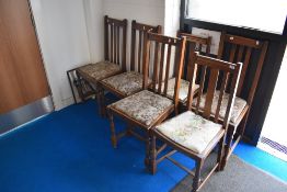 A harlequin set of six early 20th Century oak rail back dining chairs