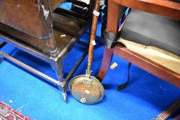 A traditional brass warming pan of small proportions