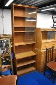 An Arts and Crafts style golden oak bookshelf, with glass to top section
