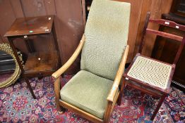 A vintage Arts and Crafts style low seat oak framed armchair having moquette style upholstery