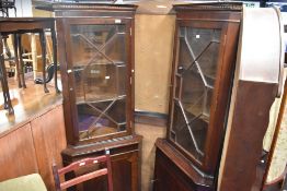 Two reproduction Regency corner display having astral glazed sections over cupboard bases