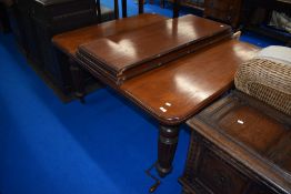 A Victorian mahogany wind out dining table on fluted legs