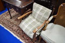 A vintage stained frame low seat armchair