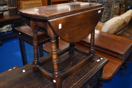 A traditional oak occasional table on turned frame