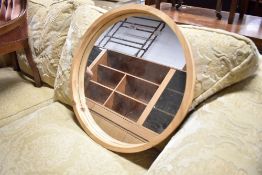 A natural wood circular wall mirror