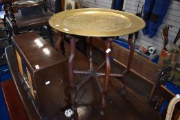 An Oriental brass table having folding bentwood frame