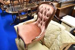 A reproduction mahogany framed balloon back nursing chair having pink dralon upholstery and button