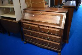 A 19th Century oak bureau having cushioned drawers