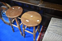 A pair of traditional stained frame kitchen stools having turned frames