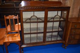An early 20th Century mahogany display cabinet having ball and claw feet