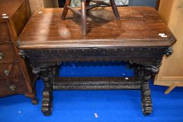 A 19th Century oak side having canted top and extensively carved frame