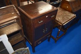 An early 20th Century oak side cabinet having central cupboard with drawers above and below