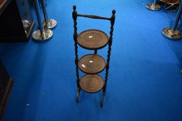 An early 20th Century oak folding cake stand