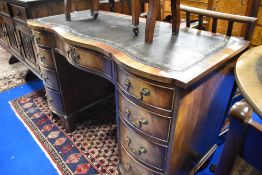 A reproduction Regency knee hole desk having serpentine front