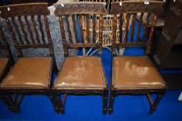 A set of six early 20th Century oak railback dining chairs having wave back