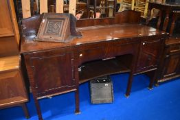 A late 19th or early 20th Century mahogany sideboard having central drawer and shelf, flanked by