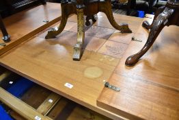 A vintage teak and tile top dining table with extending leaves