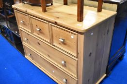 A solid pine chest of three short over two long drawers