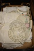 An assortment of mixed vintage table linen, including embroidered tray clothes and crotched edged